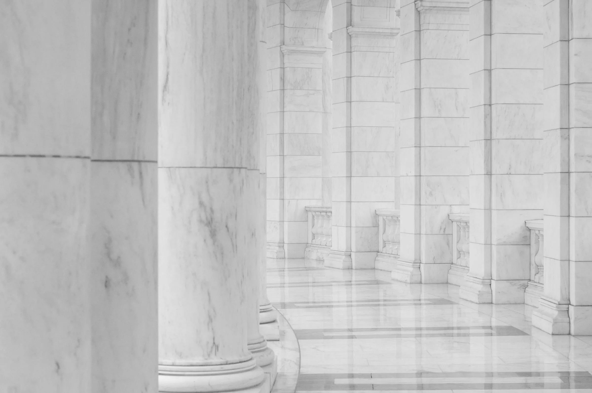 Institutional marble colonnade hallway with polished floor